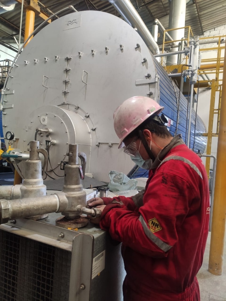Técnico qualificado executando inspeção em caldeira industrial Alfa Laval e medição de espessura de acordo com a norma regulamentadora NR-13.