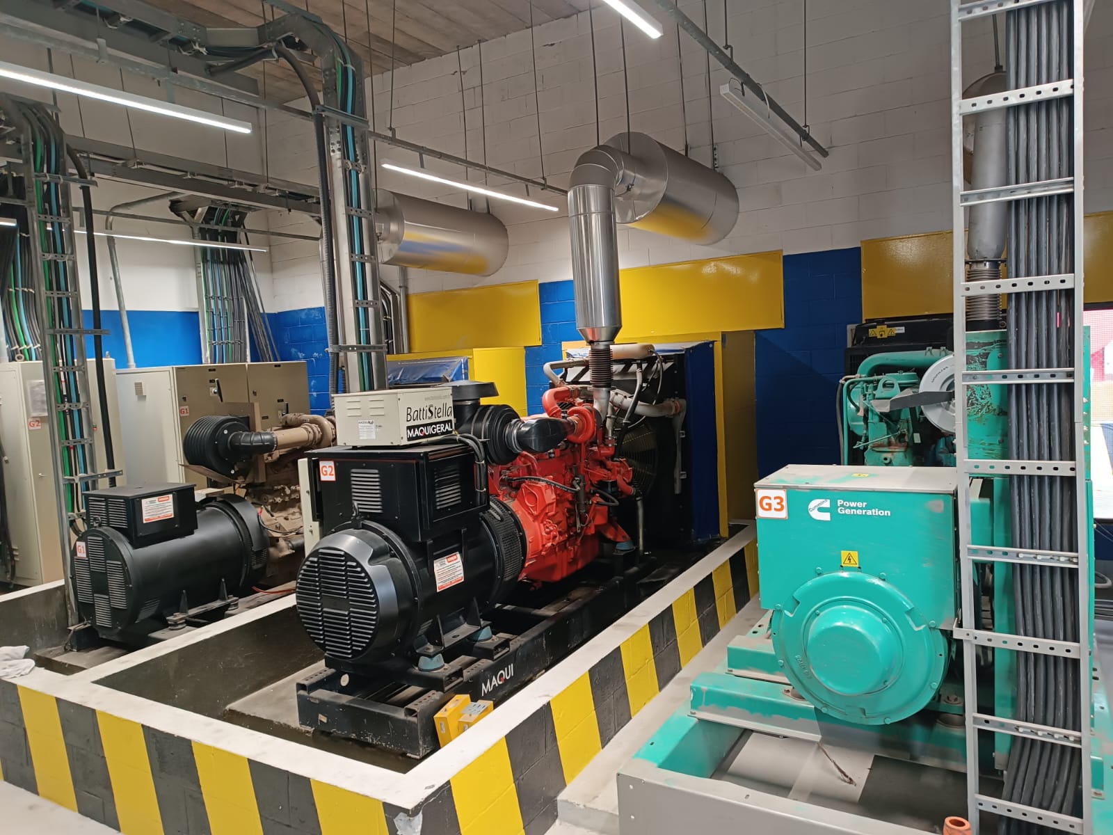 Sala de máquinas com grupos geradores industriais Cummins e Maquigeral em paralelo montados pela EngLog Engenharia.